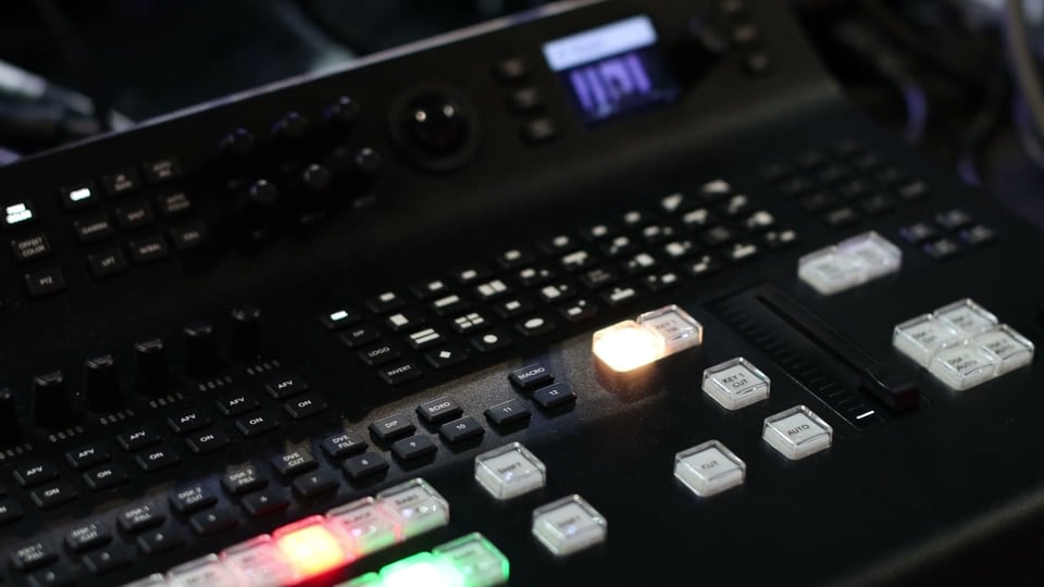 Macro move across a vision mixer, lit buttons in red and green
