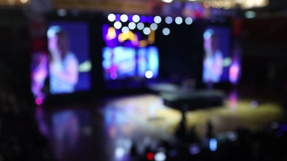 Defocused stage with performer screens and bokeh lights