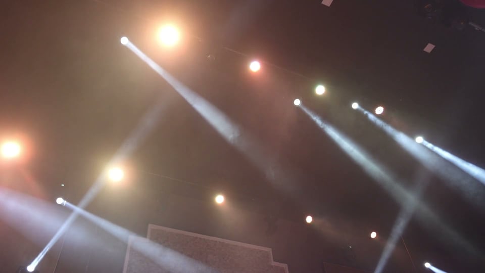 Hard crossing beams over a hazy stage in amber and purple