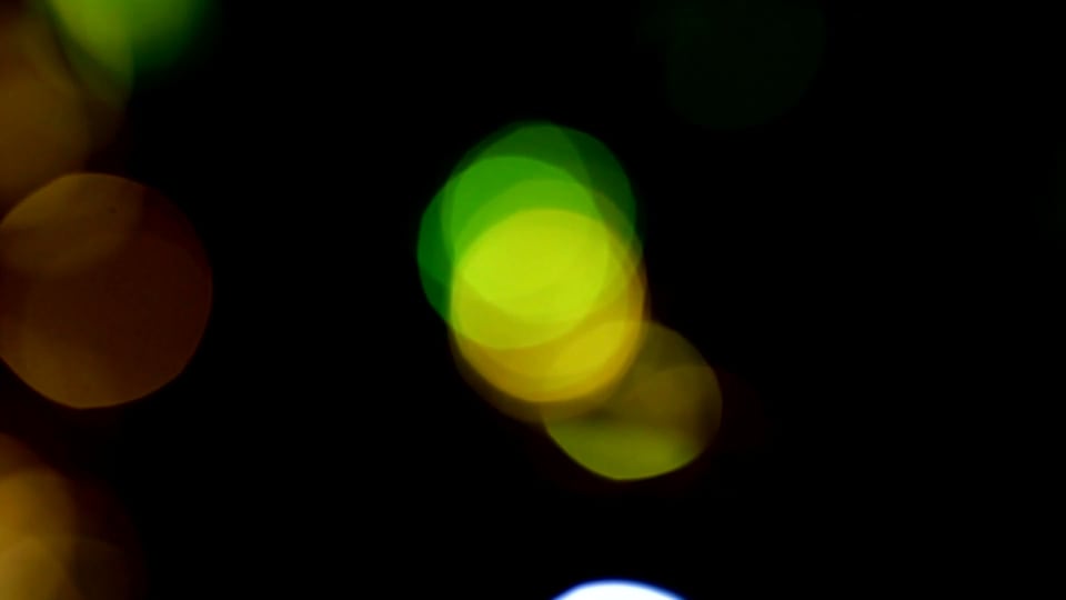 Coloured bokeh orbs drifting in and out on black